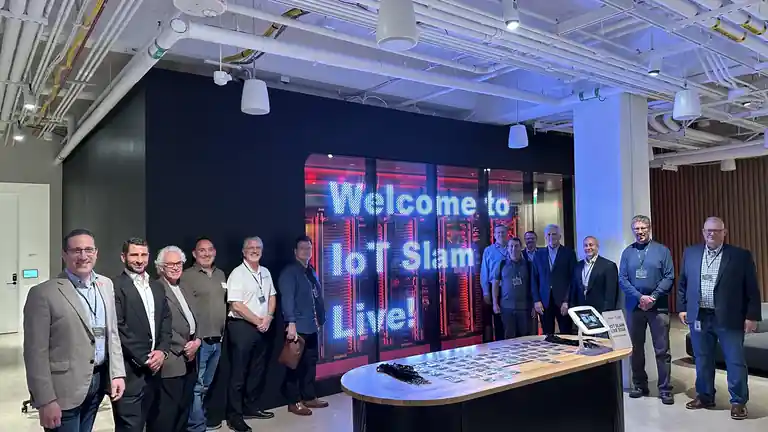 IoT Slam Live attendees gathered beside the Welcome to IoT Slam Live display.